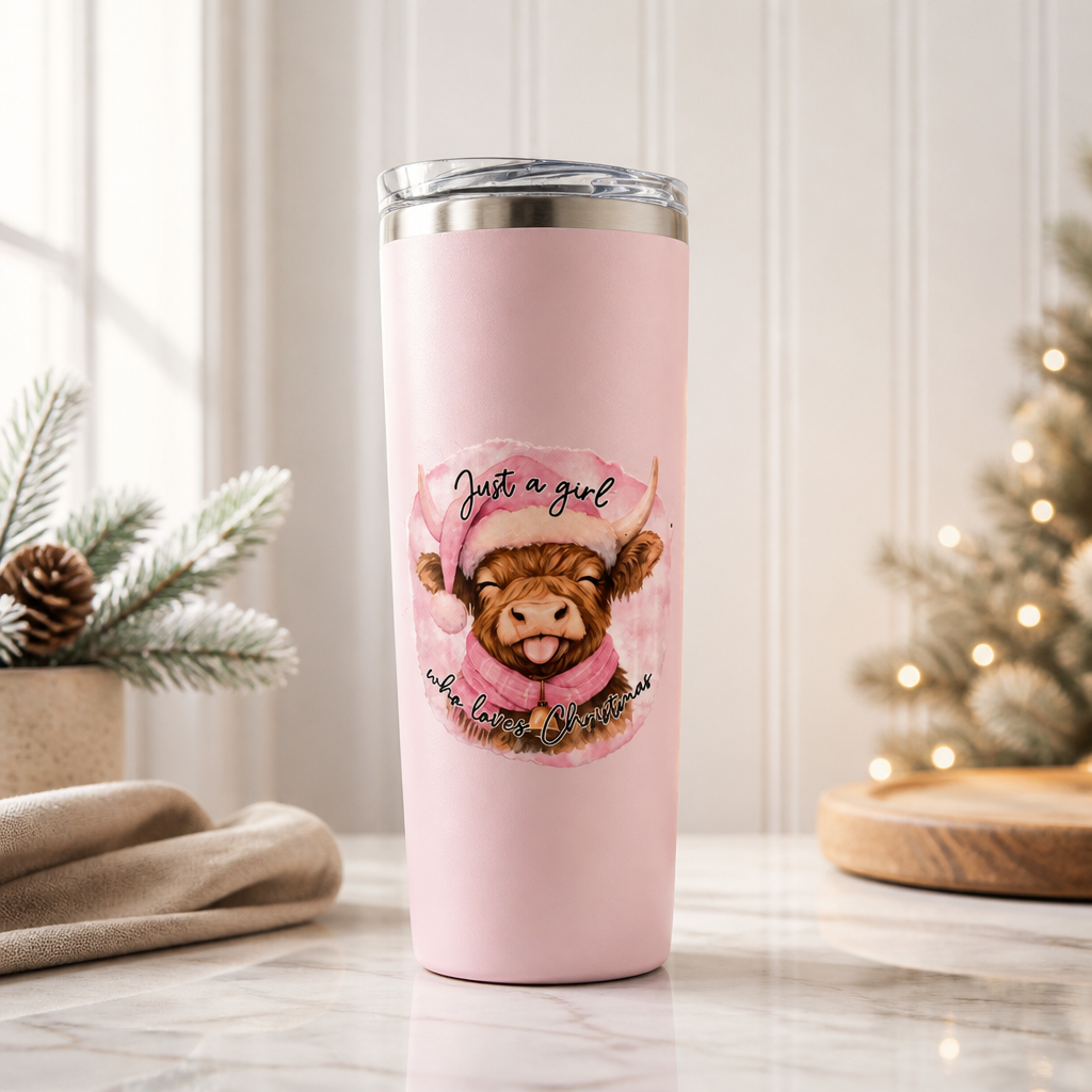 This pink, 20 oz tumbler features a printed illustration of a brown highland cow wearing a pink Santa hat and scarf, with the text 'Just a girl who loves Christmas' written around the cute cow! What a fun way to celebrate the season!